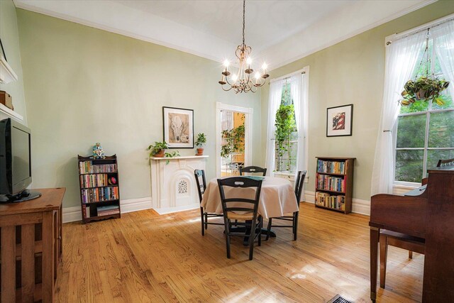 1785 Glenwood Pl, Memphis, TN 38104 - dining space with a chandelier, light wood-style flooring, and crown molding