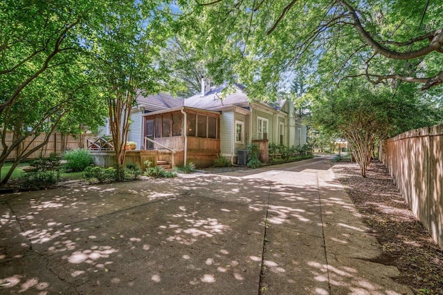 1785 Glenwood Pl, Memphis, TN 38104 - view of front of home with a sunroom, a fenced backyard, a patio area, and a chimney