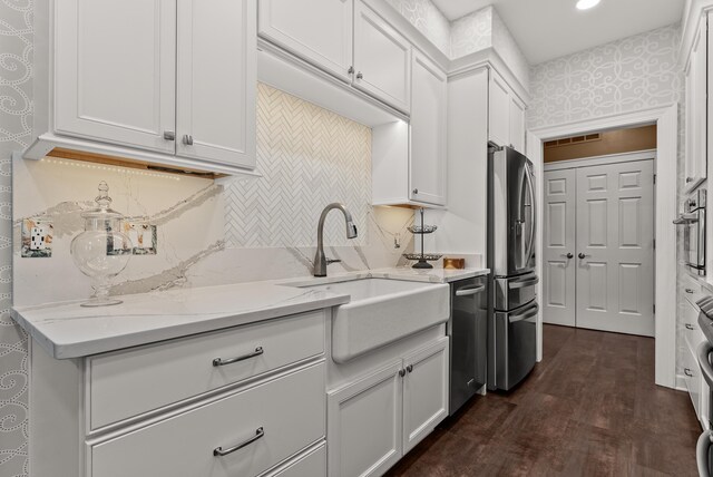 232 Windover Grove Dr, Memphis, TN 38111 - kitchen featuring appliances with stainless steel finishes, white cabinets, dark wood finished floors, light stone counters, and decorative backsplash