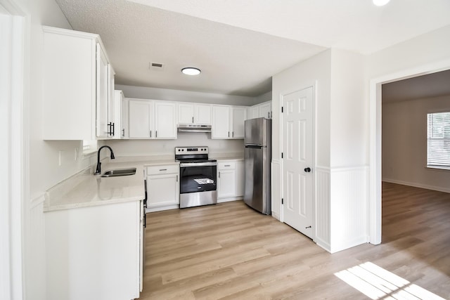 7881 Collins Wood Cv, Memphis, TN 38125 - kitchen with appliances with stainless steel finishes, under cabinet range hood, light countertops, and light wood finished floors