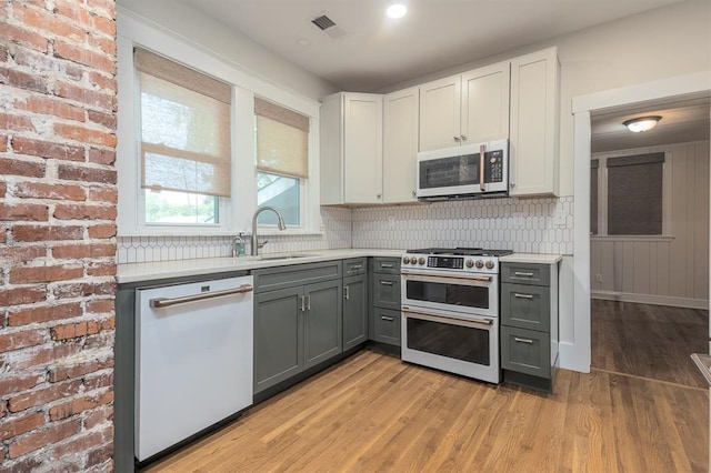 1622 Tutwiler Ave, Memphis, TN 38107 - kitchen with white dishwasher, double oven range, gray cabinets, light countertops, and light wood-type flooring