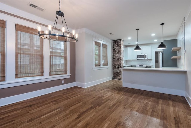 1622 Tutwiler Ave, Memphis, TN 38107 - kitchen featuring appliances with stainless steel finishes, a chandelier, dark wood-style floors, backsplash, and white cabinetry