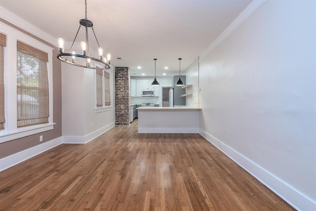 1622 Tutwiler Ave, Memphis, TN 38107 - unfurnished living room featuring a chandelier, dark wood-type flooring, ornamental molding, and recessed lighting