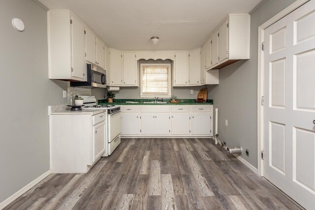 3806 Bluff Rd, Hernando, MS 38632 - kitchen with white range with gas stovetop, stainless steel microwave, dark wood-type flooring, and white cabinetry