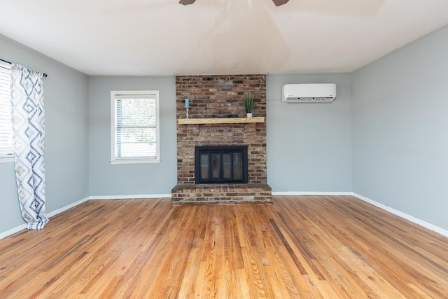 3806 Bluff Rd, Hernando, MS 38632 - unfurnished living room with a wall mounted AC, a ceiling fan, wood finished floors, and a fireplace