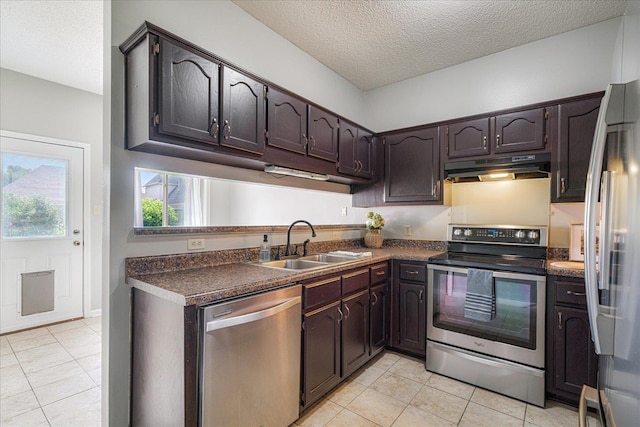 772 Breeze Way, Cordova, TN 38018 - kitchen featuring appliances with stainless steel finishes, under cabinet range hood, dark countertops, light tile patterned floors, and a textured ceiling
