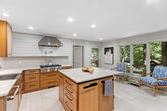 9240 Riveredge Dr, Memphis, TN 38018 - kitchen with stainless steel gas stovetop, wall chimney exhaust hood, light stone counters, a kitchen island, and dishwashing machine