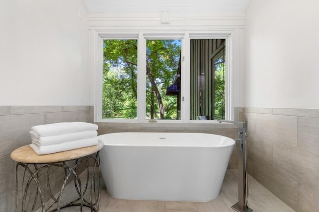 9240 Riveredge Dr, Memphis, TN 38018 - bathroom with tile walls, a soaking tub, and a wainscoted wall