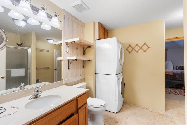 9240 Riveredge Dr, Memphis, TN 38018 - ensuite bathroom featuring stacked washer / dryer, a shower stall, vanity, and tile patterned flooring