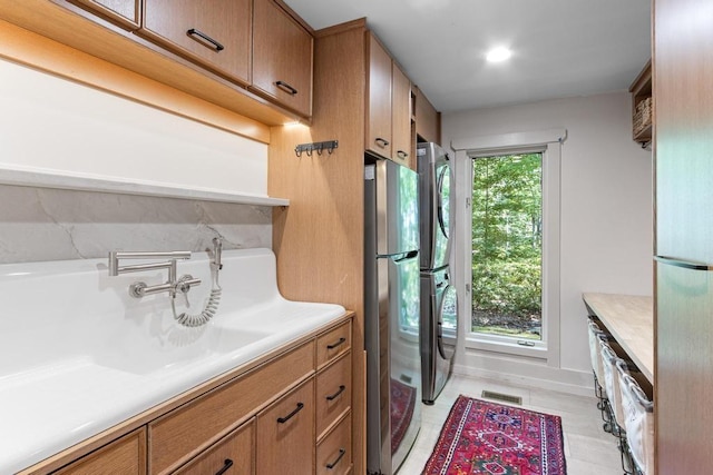 9240 Riveredge Dr, Memphis, TN 38018 - laundry area with stacked washer / dryer and light tile patterned floors