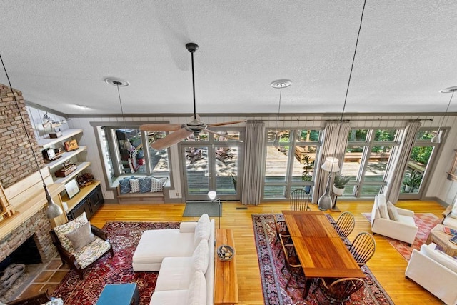 9240 Riveredge Dr, Memphis, TN 38018 - living area featuring a textured ceiling, wood finished floors, a fireplace, healthy amount of natural light, and a ceiling fan