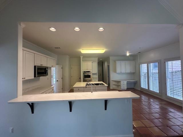 6425 Lebarrett Cv, Memphis, TN 38120 - kitchen featuring stainless steel appliances, a peninsula, a kitchen breakfast bar, light countertops, and recessed lighting