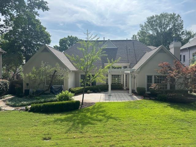 6425 Lebarrett Cv, Memphis, TN 38120 - back of property featuring a patio, a lawn, stucco siding, and a pergola