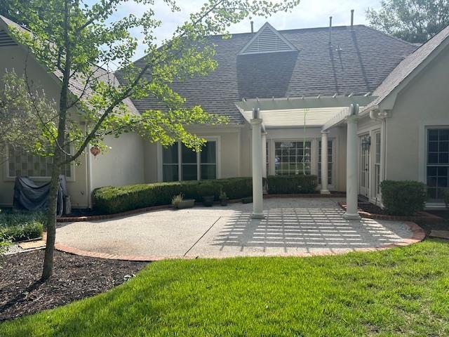 6425 Lebarrett Cv, Memphis, TN 38120 - rear view of house featuring a patio area, stucco siding, a shingled roof, and a lawn