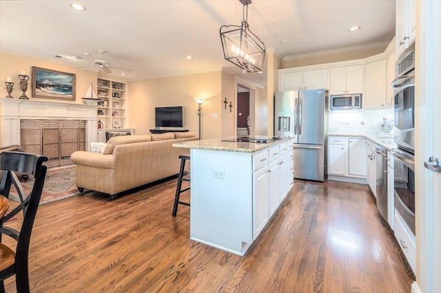 1506 Wolf Bend Rd, Germantown, TN 38138 - kitchen with appliances with stainless steel finishes, crown molding, wood finished floors, white cabinets, and a center island