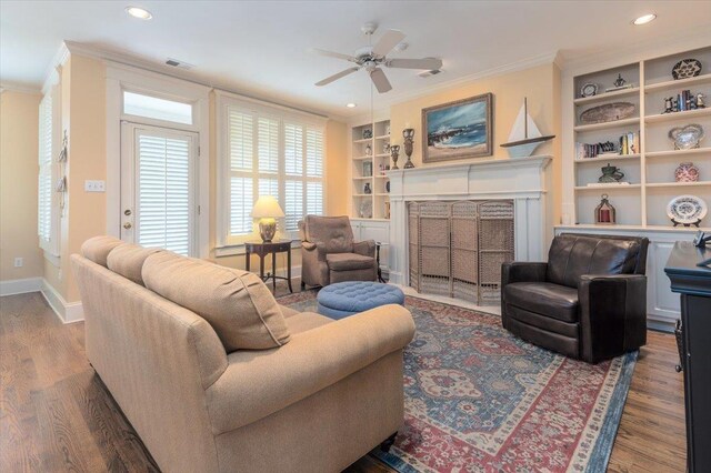 1506 Wolf Bend Rd, Germantown, TN 38138 - living area with crown molding, a fireplace with flush hearth, built in shelves, ceiling fan, and wood finished floors