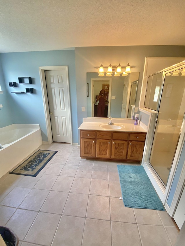 1121 W Red Fern Cir W, Cordova, TN 38018 - full bathroom with tile patterned flooring, a shower stall, vanity, a garden tub, and a textured ceiling