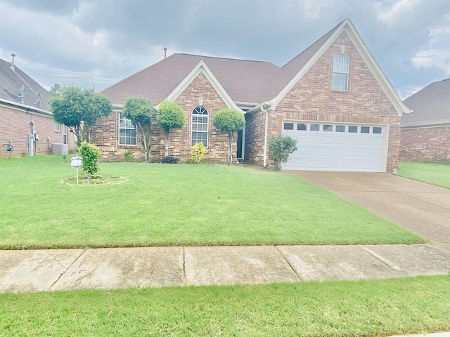 1121 W Red Fern Cir W, Cordova, TN 38018 - view of front of house with brick siding, a front lawn, driveway, a shingled roof, and a garage
