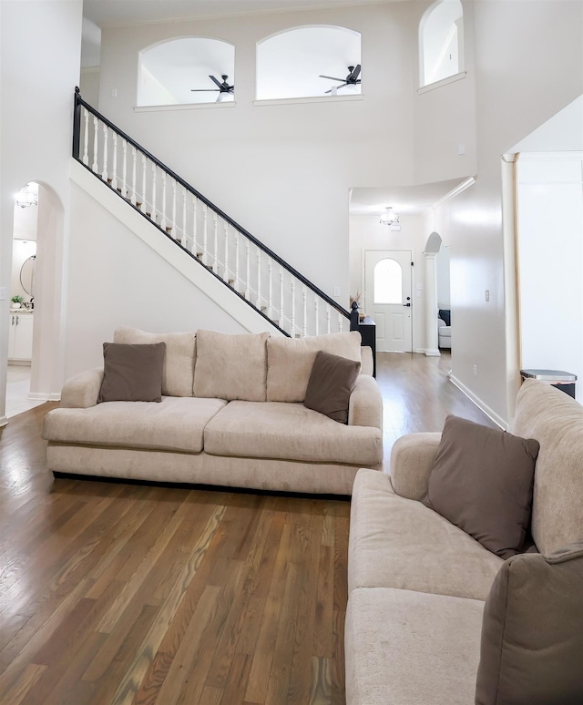 8510 Wolf Trace Ln, Bartlett, TN 38133 - living room with ceiling fan, arched walkways, a towering ceiling, stairs, and wood finished floors