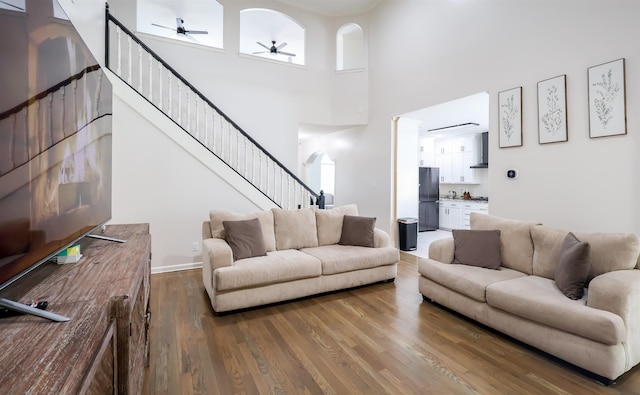 8510 Wolf Trace Ln, Bartlett, TN 38133 - living room featuring stairway, a ceiling fan, wood finished floors, and a towering ceiling