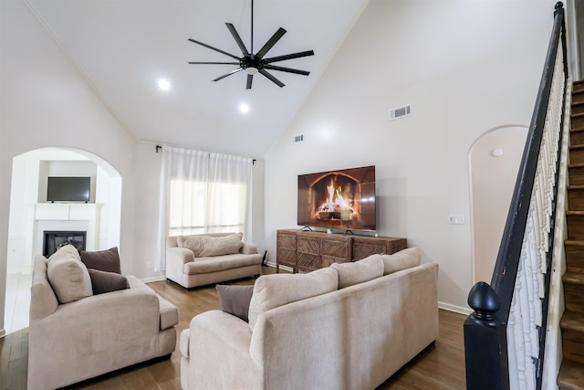 8510 Wolf Trace Ln, Bartlett, TN 38133 - living room featuring stairs, high vaulted ceiling, a ceiling fan, a glass covered fireplace, and wood finished floors