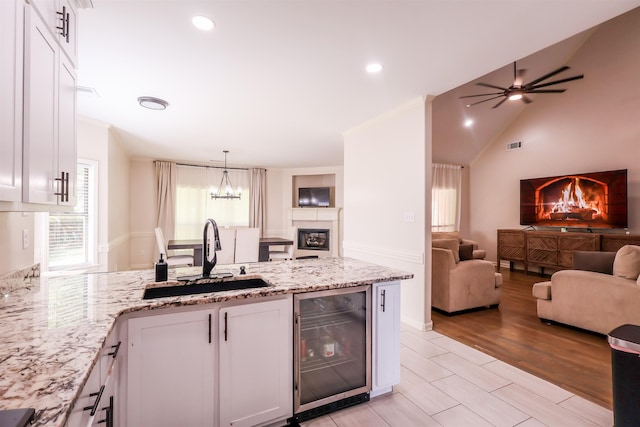 8510 Wolf Trace Ln, Bartlett, TN 38133 - kitchen with beverage cooler, open floor plan, a peninsula, white cabinets, and light stone countertops