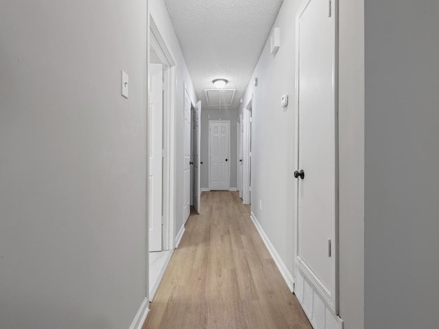 1438 Silver St, Memphis, TN 38106 - hallway featuring attic access, a textured ceiling, and light wood-style floors