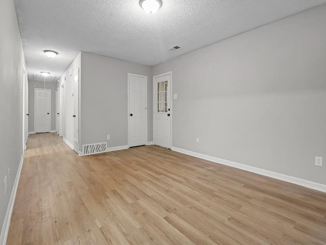 1438 Silver St, Memphis, TN 38106 - spare room with a textured ceiling, light wood-type flooring, and attic access