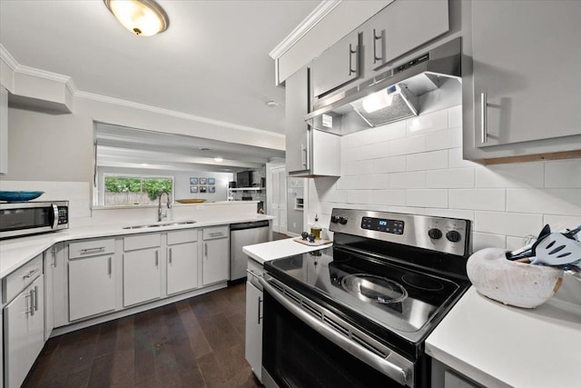4583 E Dearing Rd, Memphis, TN 38117 - kitchen with stainless steel appliances, under cabinet range hood, light countertops, backsplash, and ornamental molding