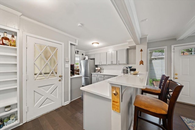 4583 E Dearing Rd, Memphis, TN 38117 - kitchen featuring freestanding refrigerator, a kitchen breakfast bar, a peninsula, crown molding, and dark wood finished floors