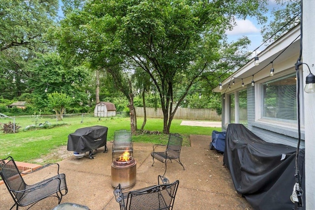4583 E Dearing Rd, Memphis, TN 38117 - fenced backyard with area for grilling, an outdoor fire pit, a shed, and a patio area