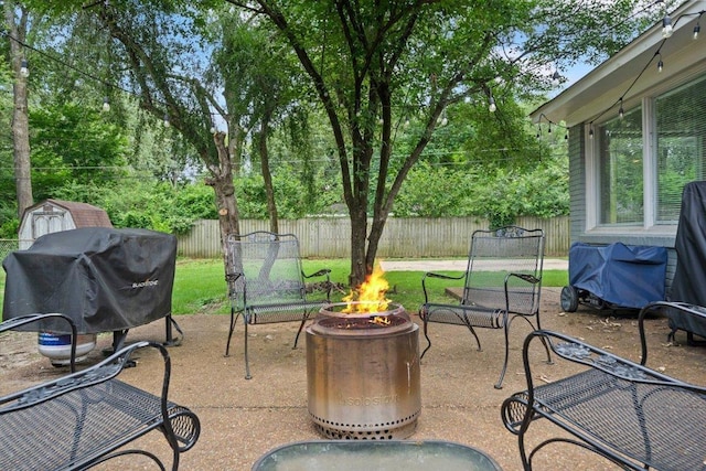 4583 E Dearing Rd, Memphis, TN 38117 - fenced backyard featuring an outdoor fire pit, a grill, a patio area, and a shed