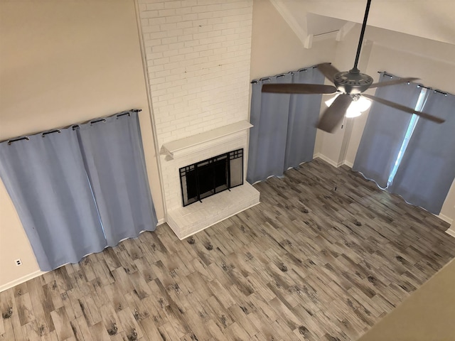 8894 Lake Edge Cv, Memphis, TN 38016 - unfurnished living room with a ceiling fan, wood finished floors, a fireplace, and vaulted ceiling