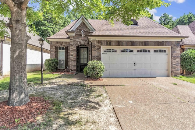 6836 Lagrange Grove Dr, Cordova, TN 38018 - french country inspired facade with a shingled roof, brick siding, an attached garage, and driveway