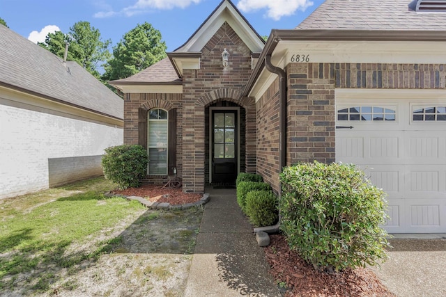 6836 Lagrange Grove Dr, Cordova, TN 38018 - view of exterior entry featuring brick siding, a garage, and roof with shingles