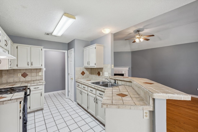 2766 Fletcher View Dr, Memphis, TN 38016 - kitchen with a peninsula, a ceiling fan, black stove, tasteful backsplash, and white cabinetry