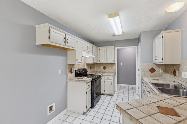 2766 Fletcher View Dr, Memphis, TN 38016 - kitchen featuring black range with electric stovetop, under cabinet range hood, backsplash, light tile patterned floors, and a textured ceiling