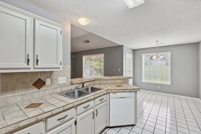 2766 Fletcher View Dr, Memphis, TN 38016 - kitchen with white dishwasher, a peninsula, tasteful backsplash, light tile patterned floors, and white cabinets