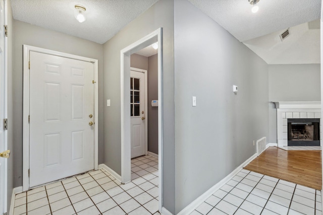 2766 Fletcher View Dr, Memphis, TN 38016 - foyer entrance featuring a textured ceiling, light tile patterned floors, and a tile fireplace