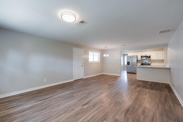 4825 Verne Rd, Memphis, TN 38117 - unfurnished living room with dark wood finished floors and a chandelier