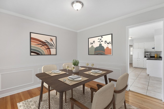 4338 Gardenview Dr, Memphis, TN 38116 - dining area featuring crown molding, light wood-style flooring, and a wainscoted wall