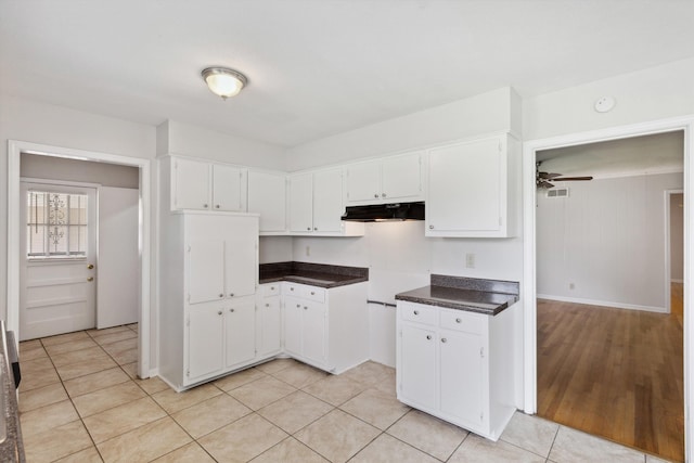 4338 Gardenview Dr, Memphis, TN 38116 - kitchen with under cabinet range hood, white cabinets, dark countertops, ceiling fan, and light tile patterned floors