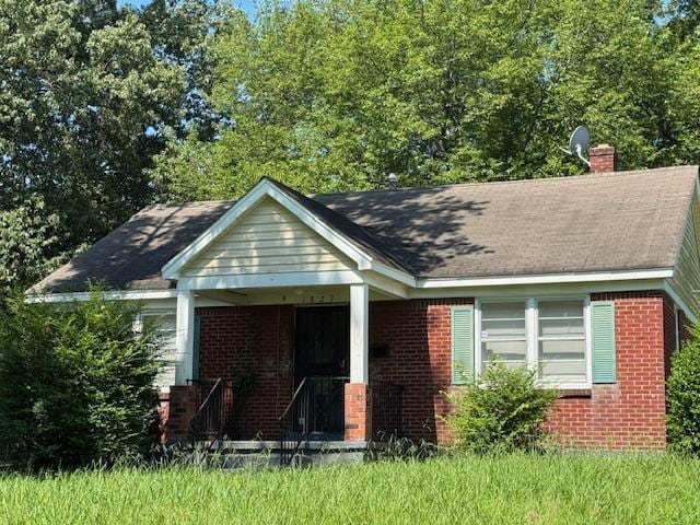1827 S Orleans Ave, Memphis, TN 38106 - bungalow-style house featuring brick siding, a chimney, and a porch