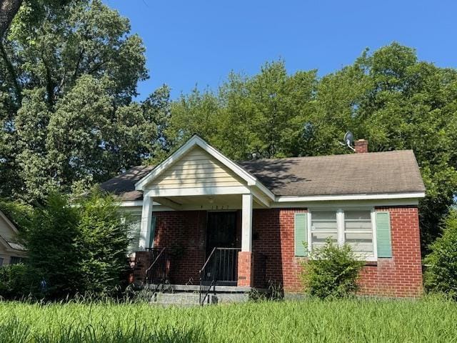 1827 S Orleans Ave, Memphis, TN 38106 - bungalow-style house with brick siding, a chimney, and a porch