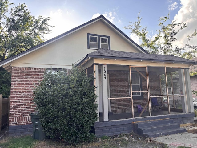 1043 Pearce St, Memphis, TN 38107 - view of property exterior featuring brick siding, a sunroom, and stucco siding