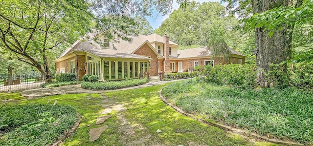4030 Windolyn Way, Bartlett, TN 38133 - rear view of house with a sunroom, a chimney, and brick siding