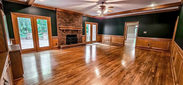 4030 Windolyn Way, Bartlett, TN 38133 - unfurnished living room featuring wainscoting, hardwood / wood-style floors, a ceiling fan, a fireplace, and ornamental molding