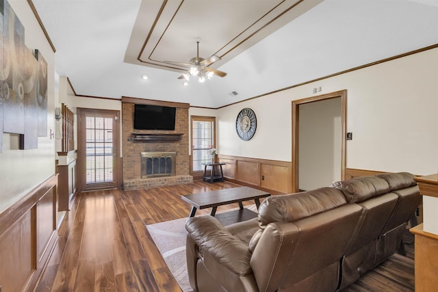4532 Quail Flight Cv, Memphis, TN 38141 - living room featuring ceiling fan, a wainscoted wall, a brick fireplace, ornamental molding, and dark wood-style flooring
