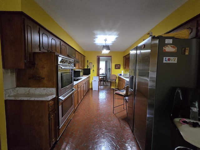 8355 Craven Rd, Bartlett, TN 38002 - kitchen featuring appliances with stainless steel finishes, light countertops, dark brown cabinets, and extractor fan