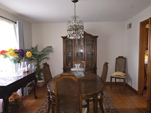 8355 Craven Rd, Bartlett, TN 38002 - dining area featuring a chandelier, wood finished floors, and a textured ceiling